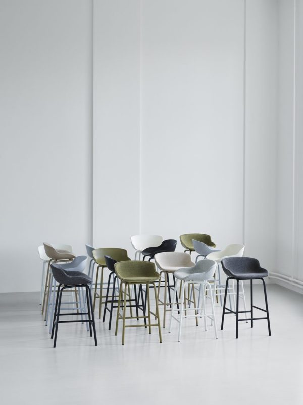 Et udvalg af moderne stole i forskellige farver og stilarter arrangeret i et lyst minimalistisk rum med hvide vægge og et lysegråt gulv, der viser det nyeste fra TomorrowsDesign.