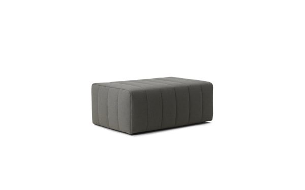 En moderne, mørkegrå NORMANN COPENHAGEN - Scene Puf Stor med et tuftet topdesign på en almindelig, lys baggrund. skammel er rektangulær i form og fremviser et enkelt og elegant look.