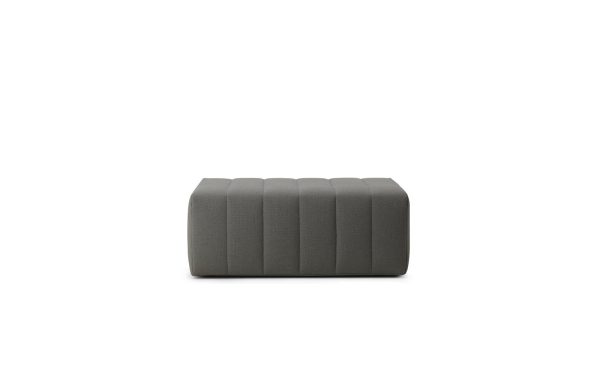 En moderne, rektangulær NORMANN COPENHAGEN - Scene Puf Stor betrukket med gråt stof med et tuftet design, isoleret på en hvid baggrund.