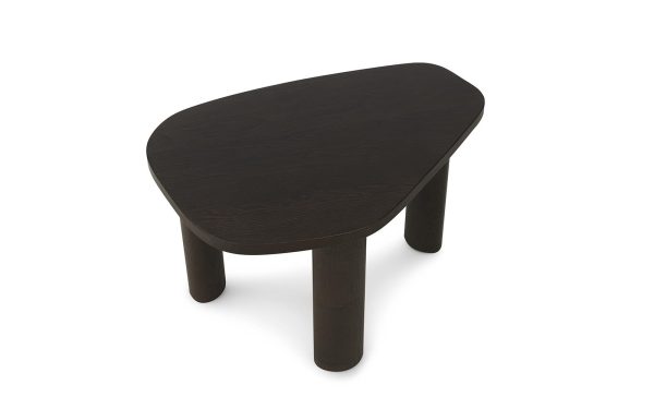 En enkel, mørk træ NORMANN COPENHAGEN - Sculp Sofabord Lille med en nyreformet top og tre cylindriske ben, isoleret på en hvid baggrund.