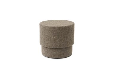 En cylindrisk NORMANN COPENHAGEN - Silo Puf Lille polstret skammel i en plettet beige farve, placeret mod en almindelig hvid baggrund.