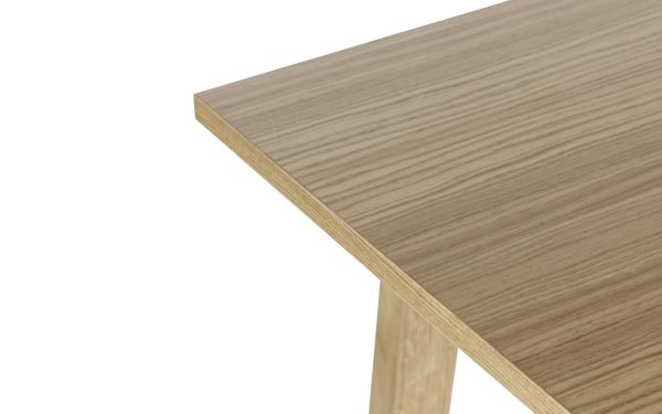 Nærbillede af et bordhjørne i lyst træ mod en hvid baggrund, der fremhæver træets struktur og åre og den vinklede kant på TomorrowsDesign bordpladen.