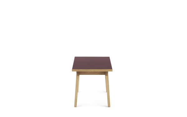 Et enkelt træbord med en firkantet plade i en mørkerød nuance, sat mod en skarp hvid baggrund. Bordet har fire slanke ben og er placeret fremadvendt, hvilket indbefatter elegancen ved TomorrowsDesign møbler.