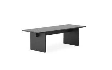 Et minimalistisk sort kontorbord med en flad rektangulær bordplade og to solide sidepaneler som ben, designet til moderne interiør, isoleret på en hvid baggrund.