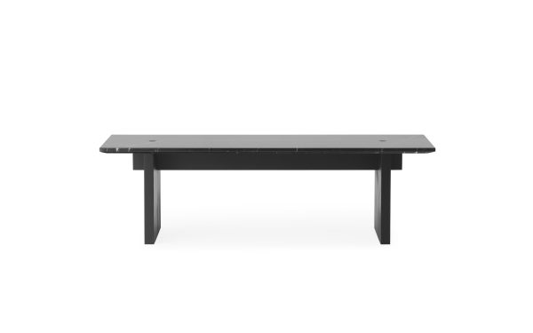 Et rektangulært sort spisebord med tilspidsede ben og et moderne design, isoleret på en hvid baggrund.