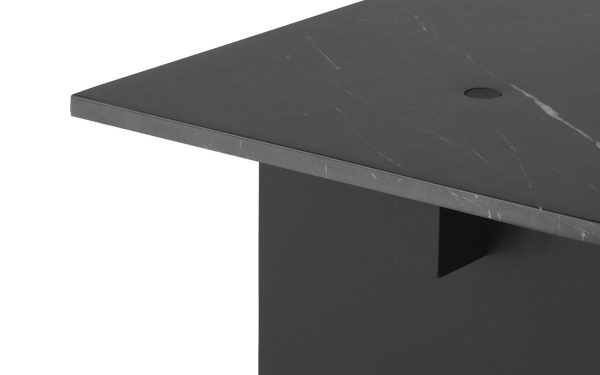 Nærbillede af en sort, rektangulær bordplade med synlige ridser og en hjørnedetalje, der understreger tykkelsen og det lille udhæng af TomorrowsDesign-overfladen.