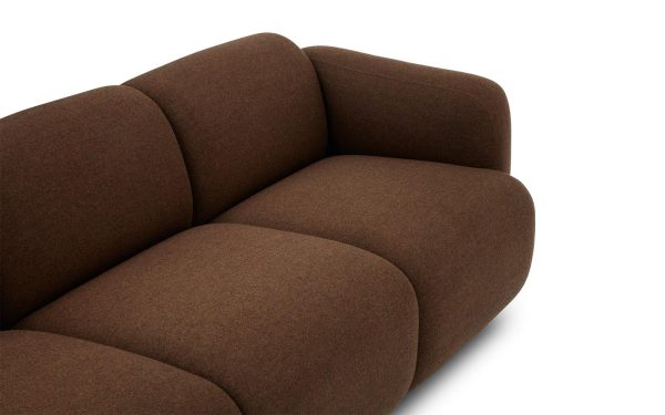 NORMANN COPENHAGEN - Swell Sofa 3 Pers. med et minimalistisk design, med glatte, afrundede kanter og betrukket med mørkebrunt stof. Sofaen er sat mod en almindelig hvid baggrund.