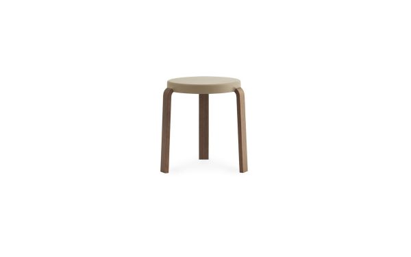 En enkel, moderne NORMANN COPENHAGEN - Tap Skammel med et rundt, beige sæde og tre brune ben, isoleret på en hvid baggrund.