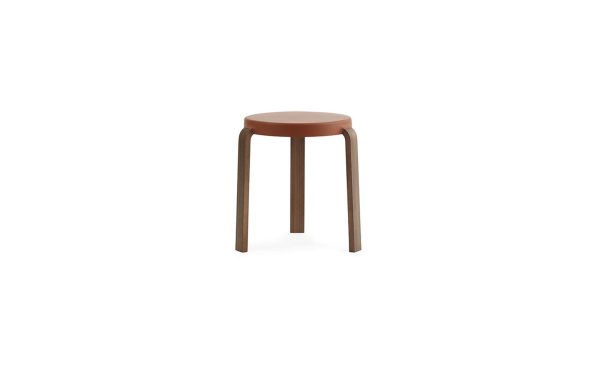 En enkel, moderne NORMANN COPENHAGEN - Tap Skammel med et rundt sæde og fire ben, isoleret på en hvid baggrund.