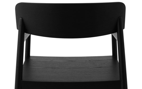 Et nærbillede af ryglænet og sædet på en moderne, mørk træstol, der viser en minimalistisk designmøbler med slanke linjer.