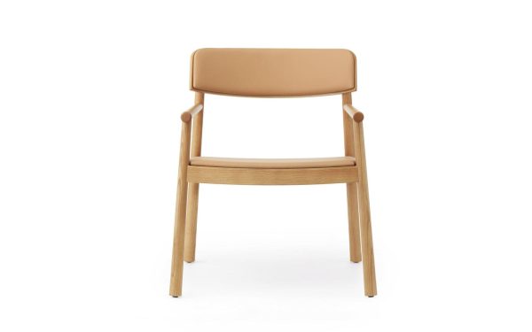 En moderne stol med stel af naturligt træ og ryg- og sædehynder i solbrun læder, isoleret på en hvid baggrund, er et klassisk eksempel på designmøbler.