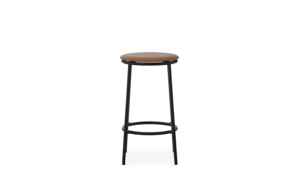 En moderne barstol med et rundt, polstret sæde i lysebrunt, anbragt på et elegant sort metalstel med en cirkulær fodstøtte og fire aflange ben. Baggrunden er almindelig hvid. Ideel til interiør-entusiaster.