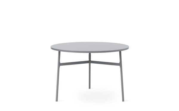 En enkel, moderne rund NORMANN COPENHAGEN - Union Spisebord Ø110 med en lysegrå top og tre sorte metalben sat mod en almindelig hvid baggrund.