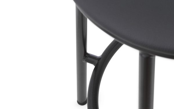 Nærbillede af et sort rundt bord fra TomorrowsDesign, der viser bordpladekanten og en del af metalbenet og dets forbindelse, sat mod en hvid baggrund.