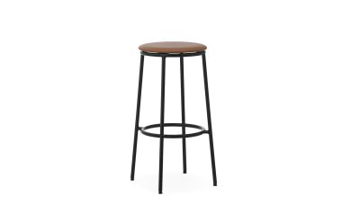 En høj skammel med en brun læderpude på toppen og et sort metalstel med slanke ben og en cirkulær fodstøtte fra TomorrowsDesign, isoleret på hvid baggrund.