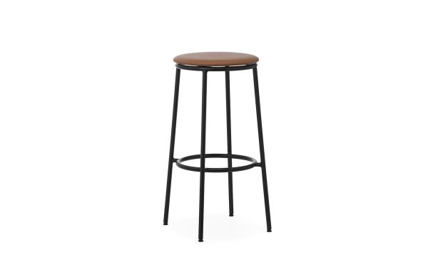 En høj skammel med en brun læderpude på toppen og et sort metalstel med slanke ben og en cirkulær fodstøtte fra TomorrowsDesign, isoleret på hvid baggrund.