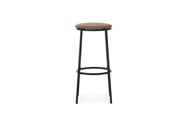 En moderne design barstol med et sort metalstel og et rundt, lysebrunt polstret sæde, isoleret på en hvid baggrund.