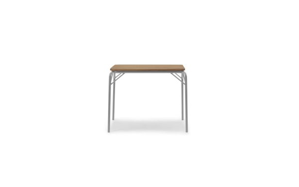 En moderne skammel med et NORMANN COPENHAGEN - Vig Bord 90X80 træsæde og slanke, sølvmetalben, isoleret på en hvid baggrund.