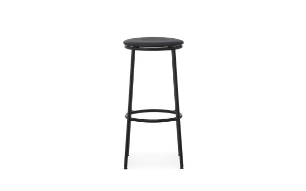 En sort barstol med rundt sæde og tynde metalben, med en enkel fodstøtte og elegant design, isoleret på en hvid baggrund.