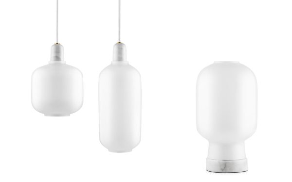 Tre hvide, cylindriske NORMANN COPENHAGEN - Amp Pendel pendellamper mod hvid baggrund. De to første hænger lodret i snore, og den tredje står oprejst på en flad base.