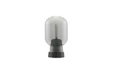 Et isoleret billede af en Normann Copenhagen - Amp Bordlampe med sort gummi- og plastikfod, vist mod en almindelig hvid baggrund.
