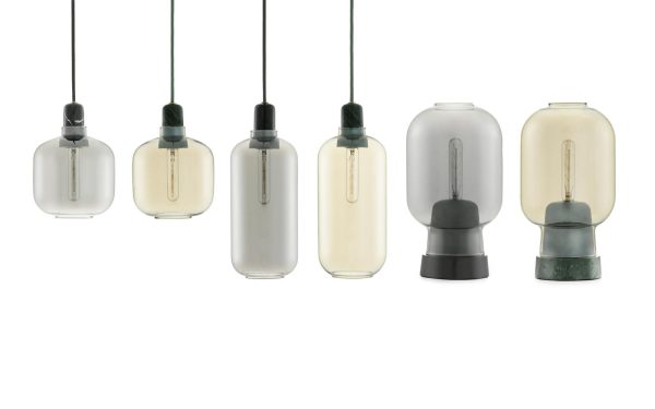 Fem NORMANN COPENHAGEN - Amp Bordlampe pendellamper med glasskærme i varierede former og minimalistiske designs, ophængt mod en hvid baggrund.