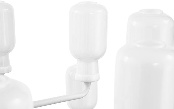 Nærbillede af indbyrdes forbundne NORMANN COPENHAGEN - Amp Lysekrone med et rør, der forbinder dem, sat mod en hvid baggrund. flaskerne har en cylindrisk form med afrundede låg.
