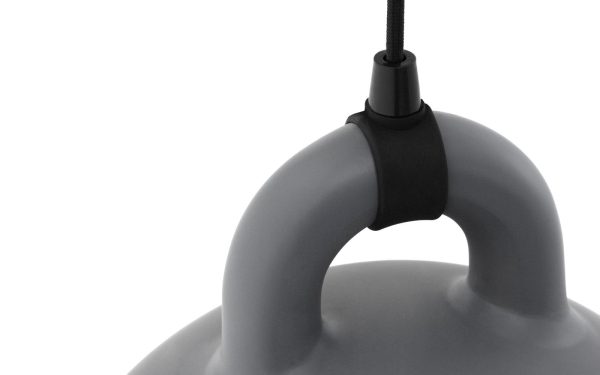 Nærbillede af en NORMANN COPENHAGEN - Bell Lampe Ø35's top, der viser det punkt, hvor den sorte snor går ind i den glatte baldakin. Baggrunden er ensartet lysegrå.