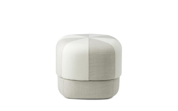 En moderne, cylindrisk skammel betrukket med lysegråt stof med en segmenteret, quiltet designmøbler, isoleret på hvid baggrund.