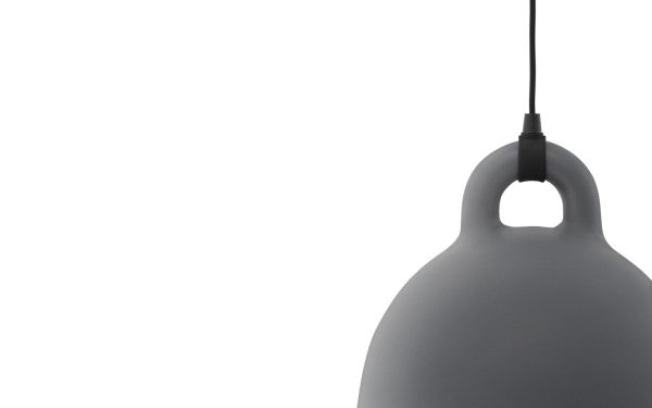 Et minimalistisk billede, der viser en NORMANN COPENHAGEN - Bell Lampe Ø55 hængende fra loftet med en mat finish, mod en almindelig hvid baggrund. lyset har en glat, afrundet form med en topløkke til fastgørelse.