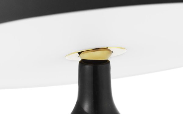 Et nærbillede af en NORMANN COPENHAGEN - Eddy Bordlampe, der viser et slankt sort stativ, der understøtter en stor, buet hvid skærm med en metallisk guldaccent, hvor stativet møder skærmen.