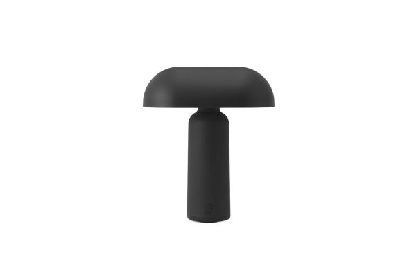 En bærbar NORMANN COPENHAGEN - Porta Bordlampe med en flad, afrundet top og cylindrisk base isoleret på en hvid baggrund. lampen har et enkelt og slankt moderne design.