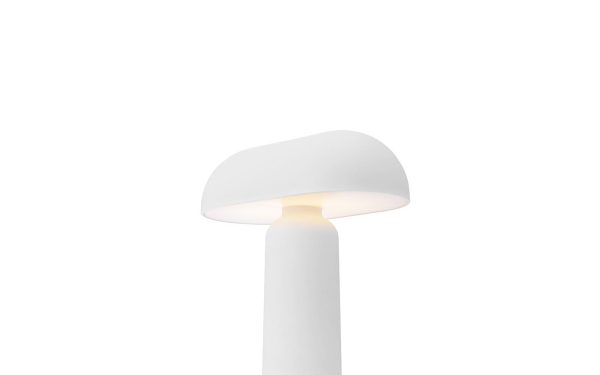 EN NORMANN COPENHAGEN - Porta Bordlampe med en cylindrisk base og en svampeformet top, oplyst med et blødt, varmt lys mod en almindelig hvid baggrund.