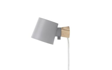 En moderne NORMANN COPENHAGEN - Rise Væglampe med en mat grå skærm og et naturligt træbeslag, forbundet til en almindelig hvid strømledning, sat mod en ren, hvid baggrund.