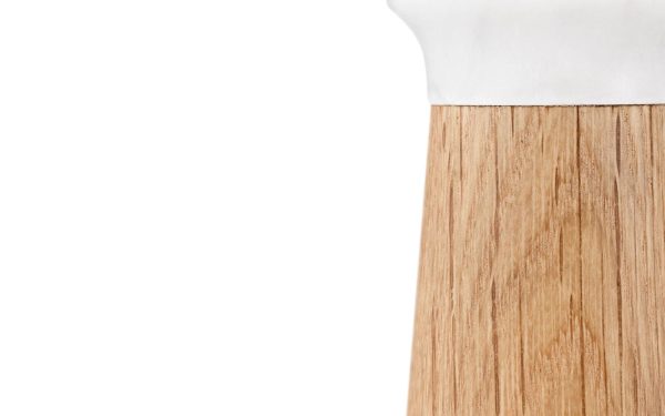 Et nærbillede af en NORMANN COPENHAGEN - Craft Saltkværn overflade, der går over til en glat hvid overflade øverst, sat mod en hvid baggrund.