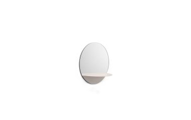 Et ovalt spejl med en lille, afrundet hylde, fastgjort til en almindelig hvid væg. designet er minimalistisk og moderne NORMANN COPENHAGEN Horizon Spejl.
