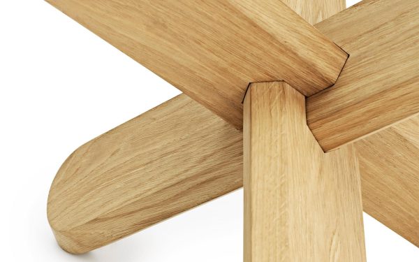 Nærbillede af et træbord, der viser leddet, hvor benet fastgøres til bordpladen, og fremhæver den glatte finish og naturlige træårer, perfekt til moderne interiørdesign.