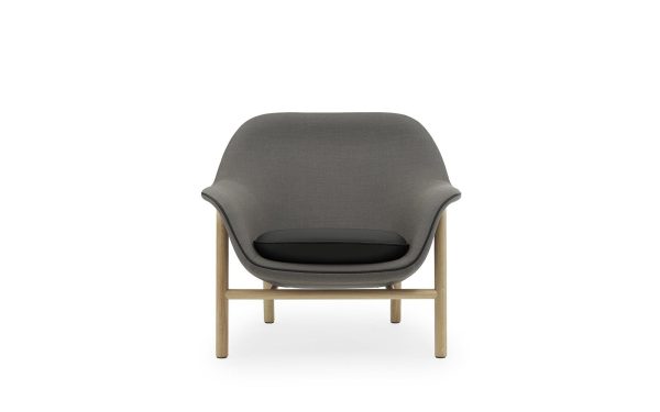 Moderne NORMANN COPENHAGEN - Drape Loungestol med gråt polstring og sort pude på en træramme, isoleret på en hvid baggrund.
