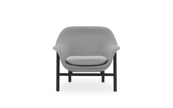 En moderne accentstol med et gråt stofbetræk og et enkelt sort metalstel, isoleret mod en hvid baggrund, fremviser elegant interiørdesign.
