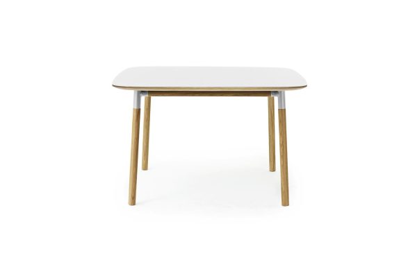 Et moderne skrivebord med en hvid rektangulær bordplade og træben, sat mod en isoleret hvid baggrund. Benene, der er forbundet med grå metalbeslag, afspejler et sofistikeret interiørdesign.