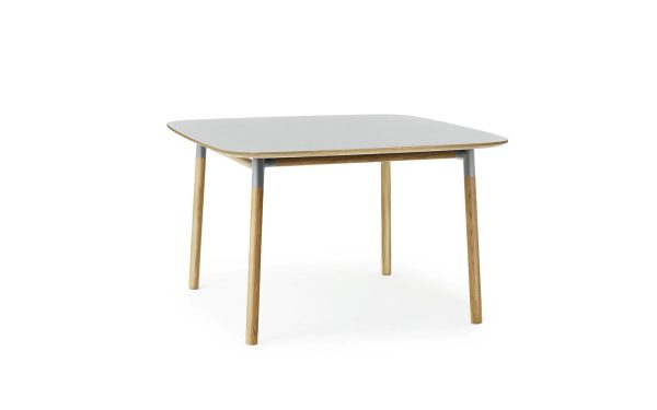Et moderne firkantet bord med en lysegrå bordplade og naturlige træben, isoleret på en hvid baggrund, fra TomorrowsDesign.