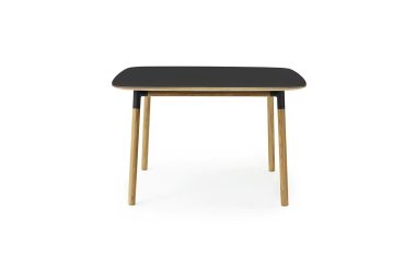 Et moderne, minimalistisk bord med en rektangulær sort plade og fire vinklede træben, isoleret på en hvid baggrund, perfekt til moderne interiørrum.