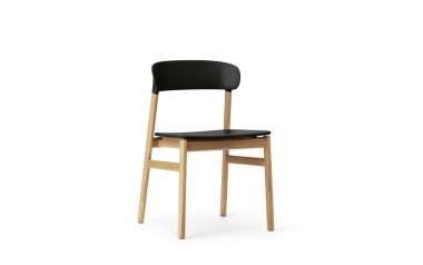 EN NORMANN COPENHAGEN - Herit Spisebordsstol med sort sæde og ryglæn, og træben, isoleret på en hvid baggrund.
