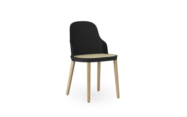 En moderne stol med et højt, solidt sort ryglæn og en beige sædehynde, sat på fire lyse træben, vist mod en almindelig hvid baggrund. Dette stykke eksemplificerer moderne design.