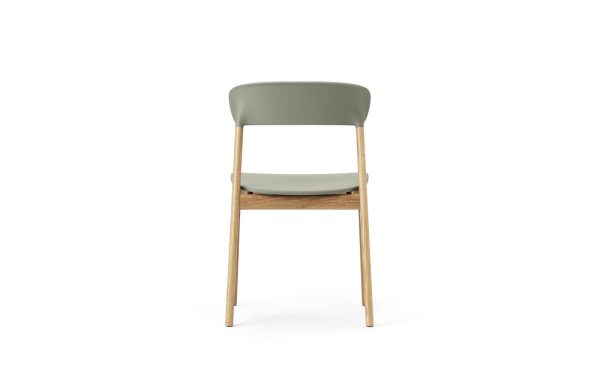 En moderne stol med et grønt sæde, træben og et møbeldesign isoleret på en hvid baggrund.