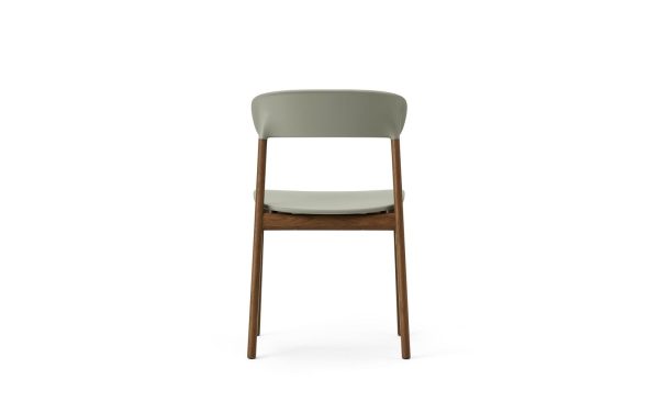 En moderne spisestuestol med stel af valnød og gråt polstret sæde og ryglæn, isoleret på en hvid baggrund, eksemplificerer TomorrowsDesign.
