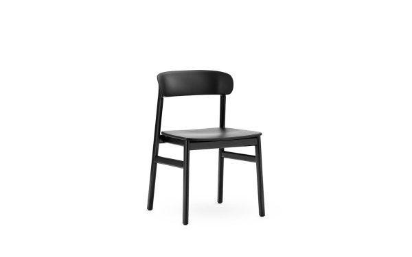 En enkel sort stol med et buet ryglæn og fire ben, vist på en almindelig hvid baggrund, som viser elegant design.