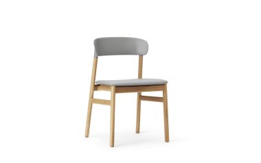 En moderne stol med træben og gråt polstret sæde og ryglæn, med designmøbler-æstetik, isoleret på hvid baggrund.