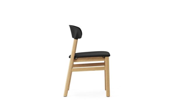 En moderne stol med sort ryglæn og sædehynde og et let træstel mod en almindelig hvid baggrund, perfekt til dem, der sætter pris på TomorrowsDesign i interiøret.