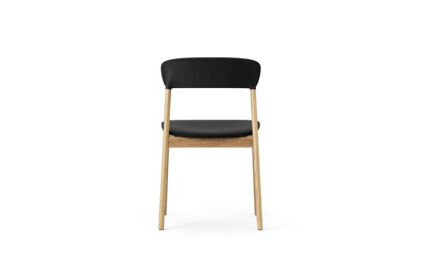 En moderne stol med sort ryglæn og sæde, og lyse træben, stående på en hvid baggrund, perfekt til moderne interiørdesign.